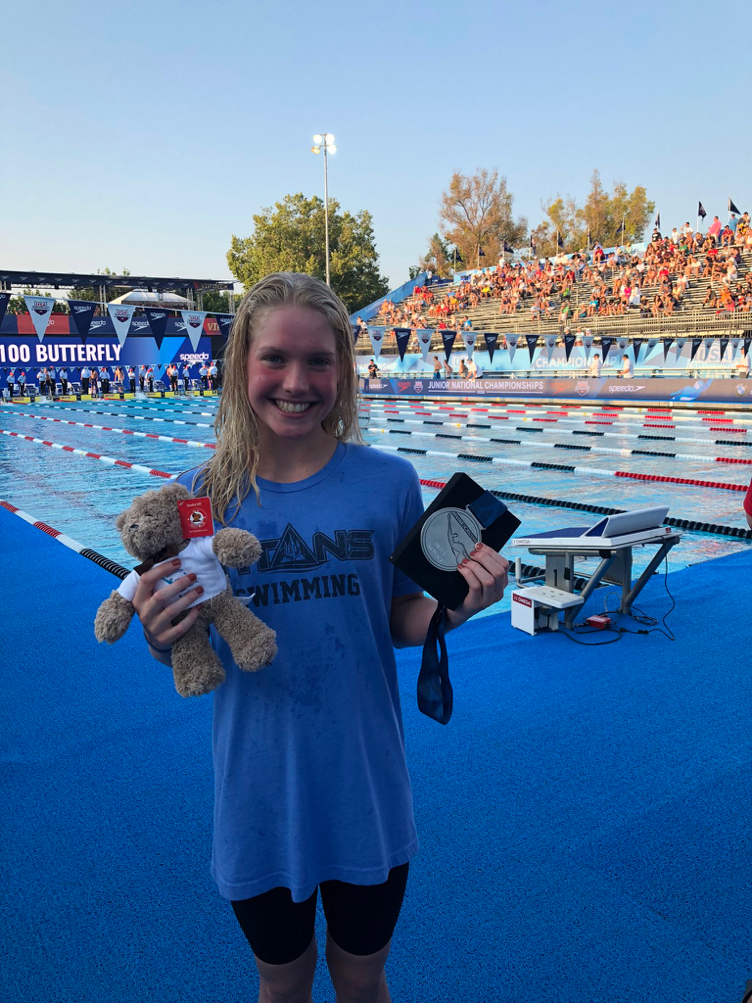Freshman Claire Curzan rises with Stanford Cardinal on path to swimming's summit 1 14-year-old Claire Curzan smiles in front of the pool, holding the medal and teddy bear she was awarded as prizes.
