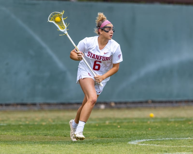 This Week in Sports: Three teams win conference titles, seven players headed to NFL 3 A womans lacrosse player runs along the field with possession of the ball