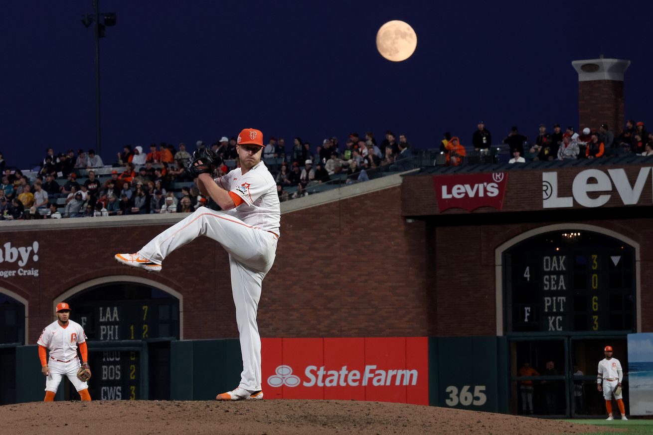 Alex Cobb throwing a pitch with a full moon in the background