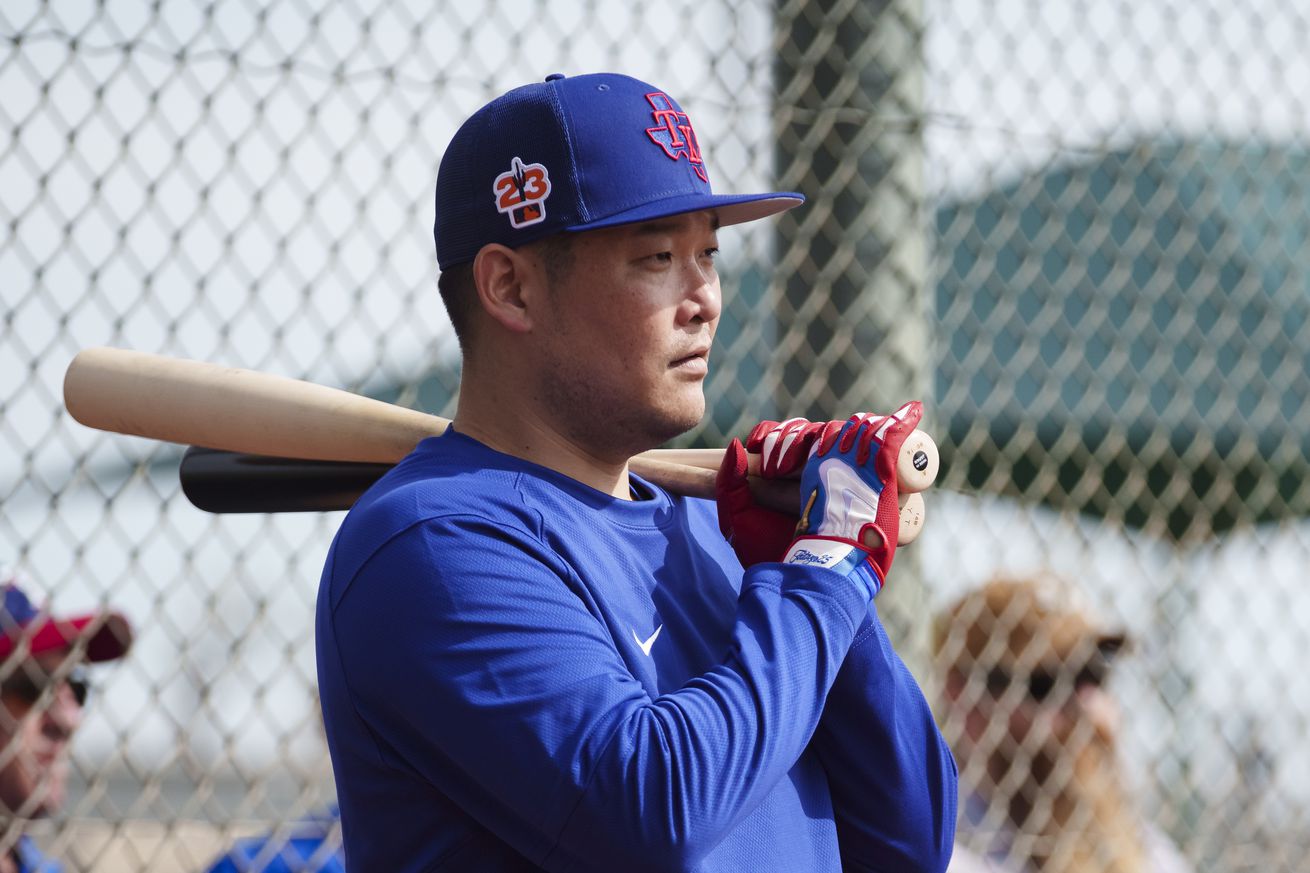Yosh Tsutsugo holding two bats on his shoulder in warm ups