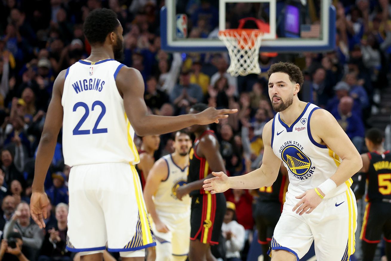 Klay Thompson #11 of the Golden State Warriors is congratulated by Andrew Wiggins #22 after he made a shot against the Atlanta Hawks in the first half at Chase Center on January 24, 2024 in San Francisco, California.