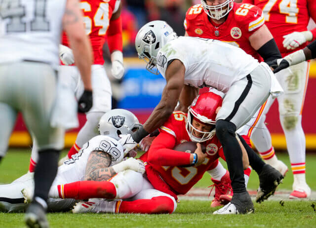Dec 25, 2023; Kansas City, Missouri, USA; Kansas City Chiefs quarterback Patrick Mahomes (15) is tackled Las Vegas Raiders defensive end Maxx Crosby (98) and linebacker Divine Deablo (5) during the second half at GEHA Field at Arrowhead Stadium. Mandatory Credit: Jay Biggerstaff-USA TODAY Sports Patrick Mahomes, Raiders, Chiefs
