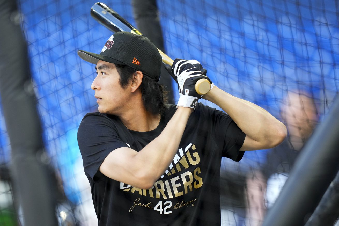 Jung Hoo Lee warming up in the batting cage while wearing a Jackie Robinson shirt.