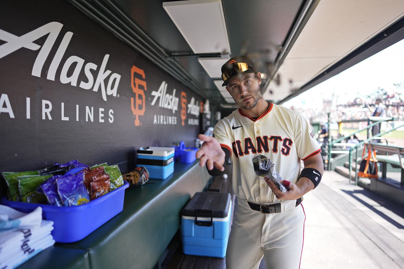 Michael Conforto in the dugout, tossing sunflower seeds at the camera. 