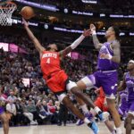 Mar 29, 2024; Salt Lake City, Utah, USA; Houston Rockets guard Jalen Green (4) stretches past Utah Jazz forward John Collins (20) and shoots the ball during the second half at Delta Center. Mandatory Credit: Chris Nicoll-USA TODAY Sports