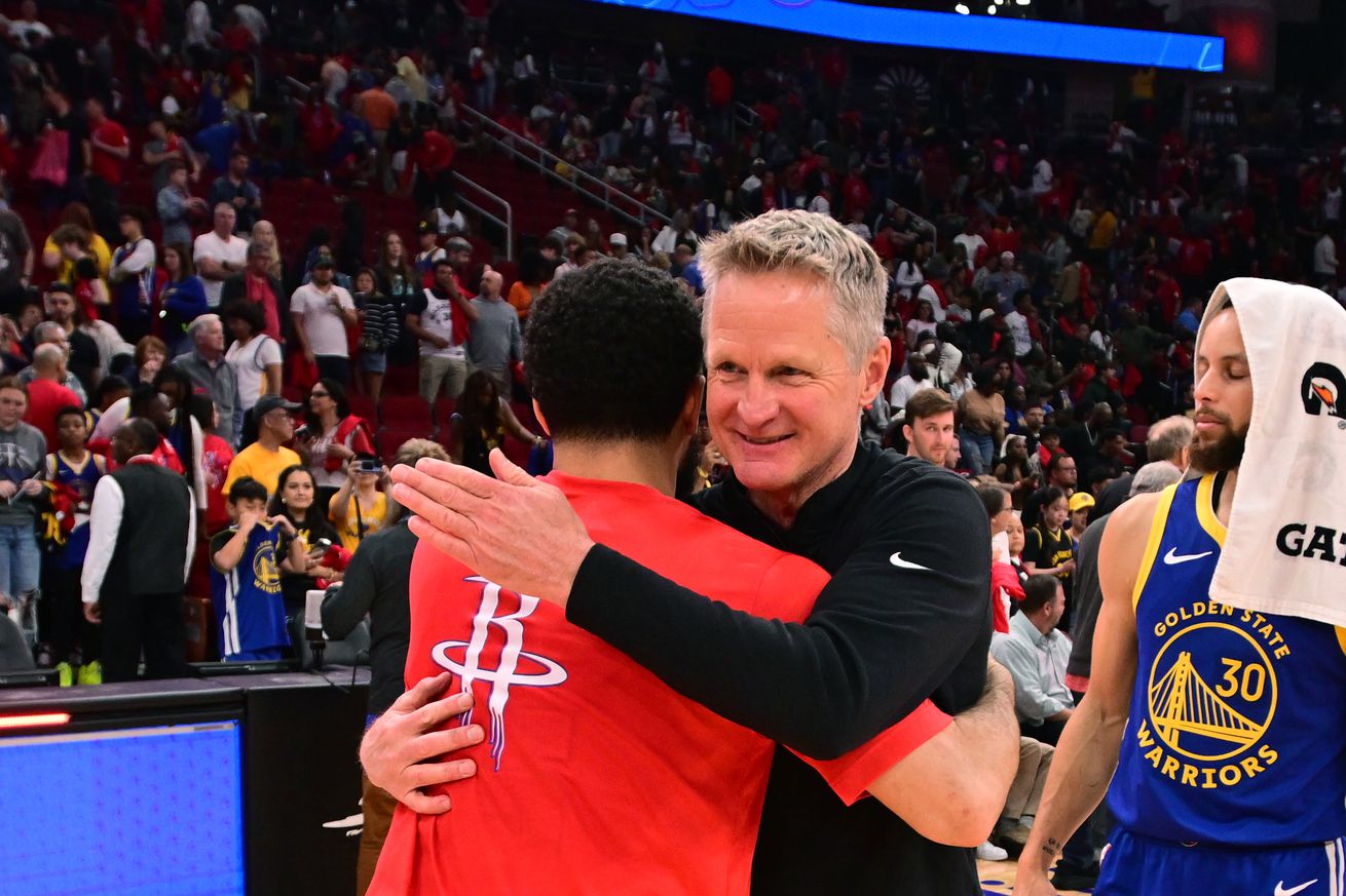 Steve Kerr hugging Fred VanVleet, with Steph Curry in the background.