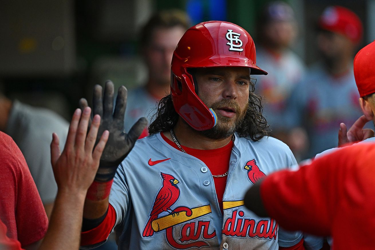 Brandon Crawford high-fiving teammates in the Cardinals dugout.