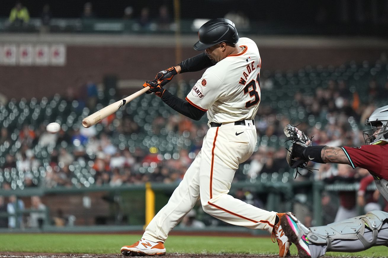 View from the side of LaMonte Wade Jr. swinging at a pitch.