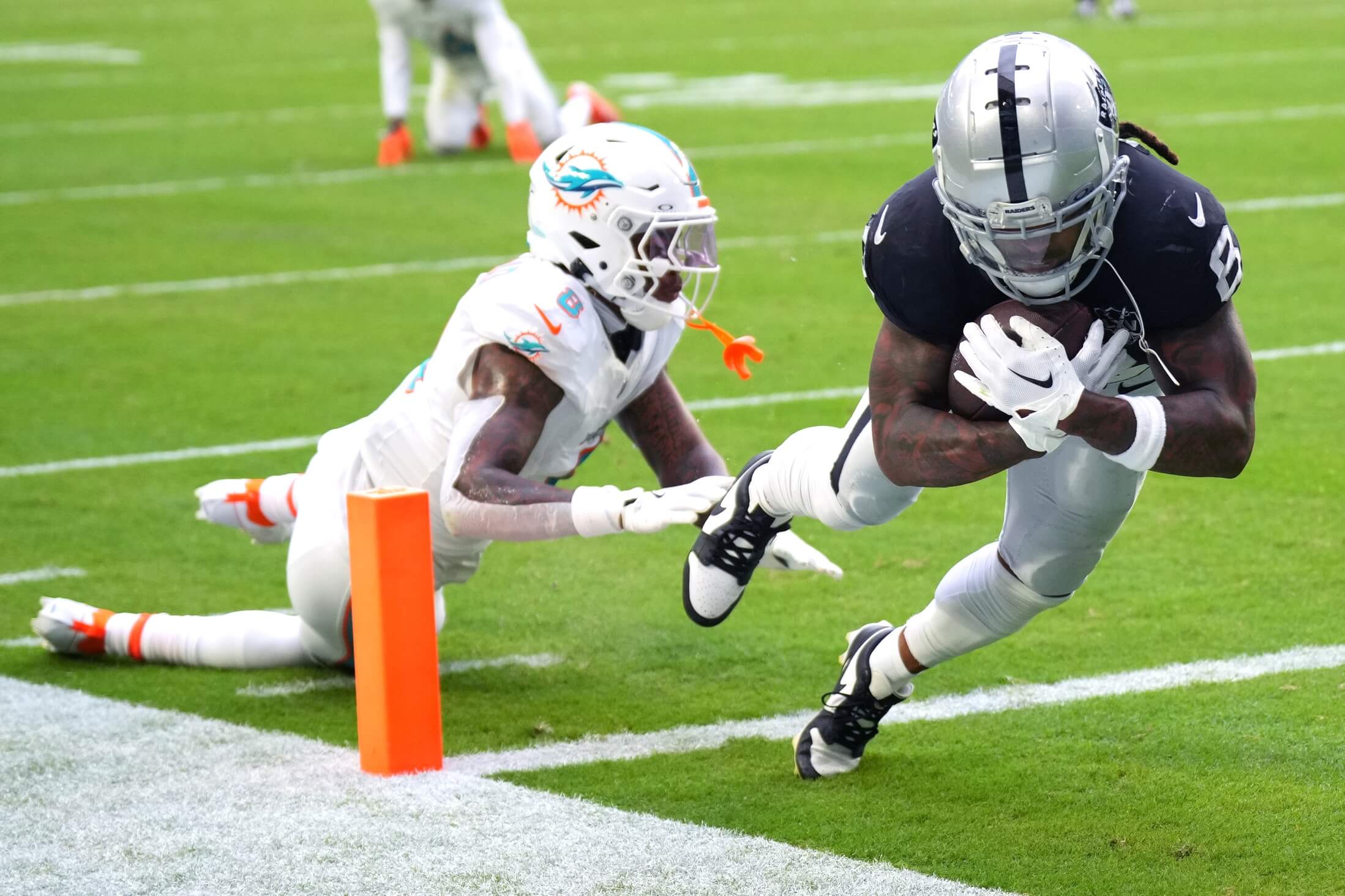 Nov 17, 2024; Miami Gardens, Florida, USA; Las Vegas Raiders running back Ameer Abdullah (8) scores a touchdown past Miami Dolphins safety Jevon Holland (8) in the fourth quarter at Hard Rock Stadium. Mandatory Credit: Jim Rassol-Imagn Images