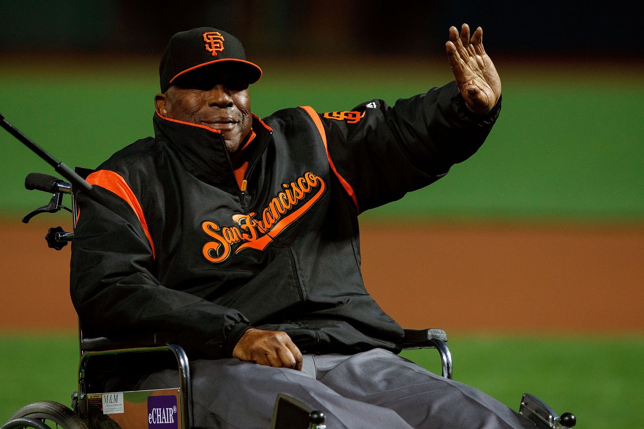 Willie McCovey in a wheelchair, waving to fans.