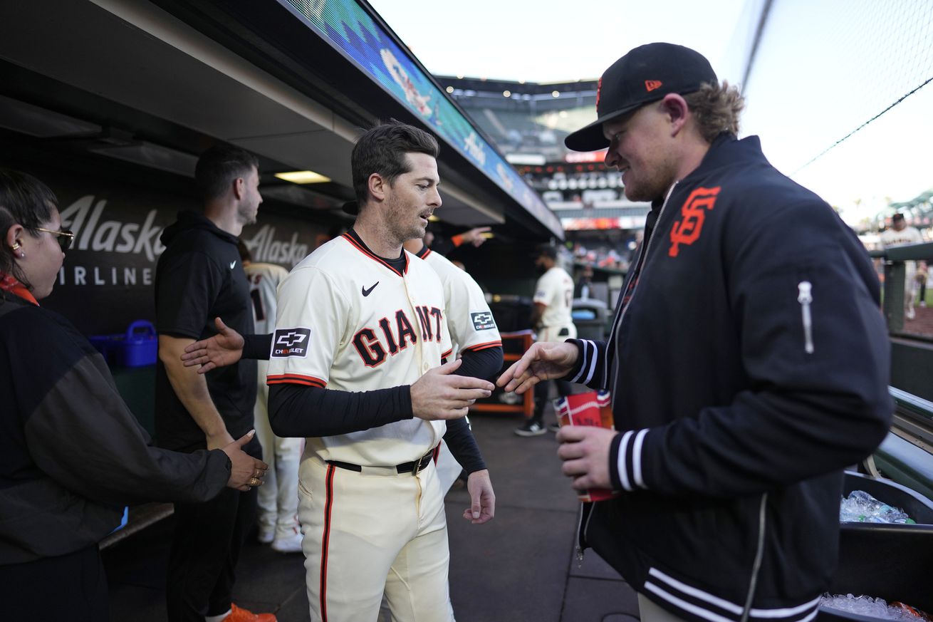 Mike Yastrzemski and Logan Webb shaking hands.
