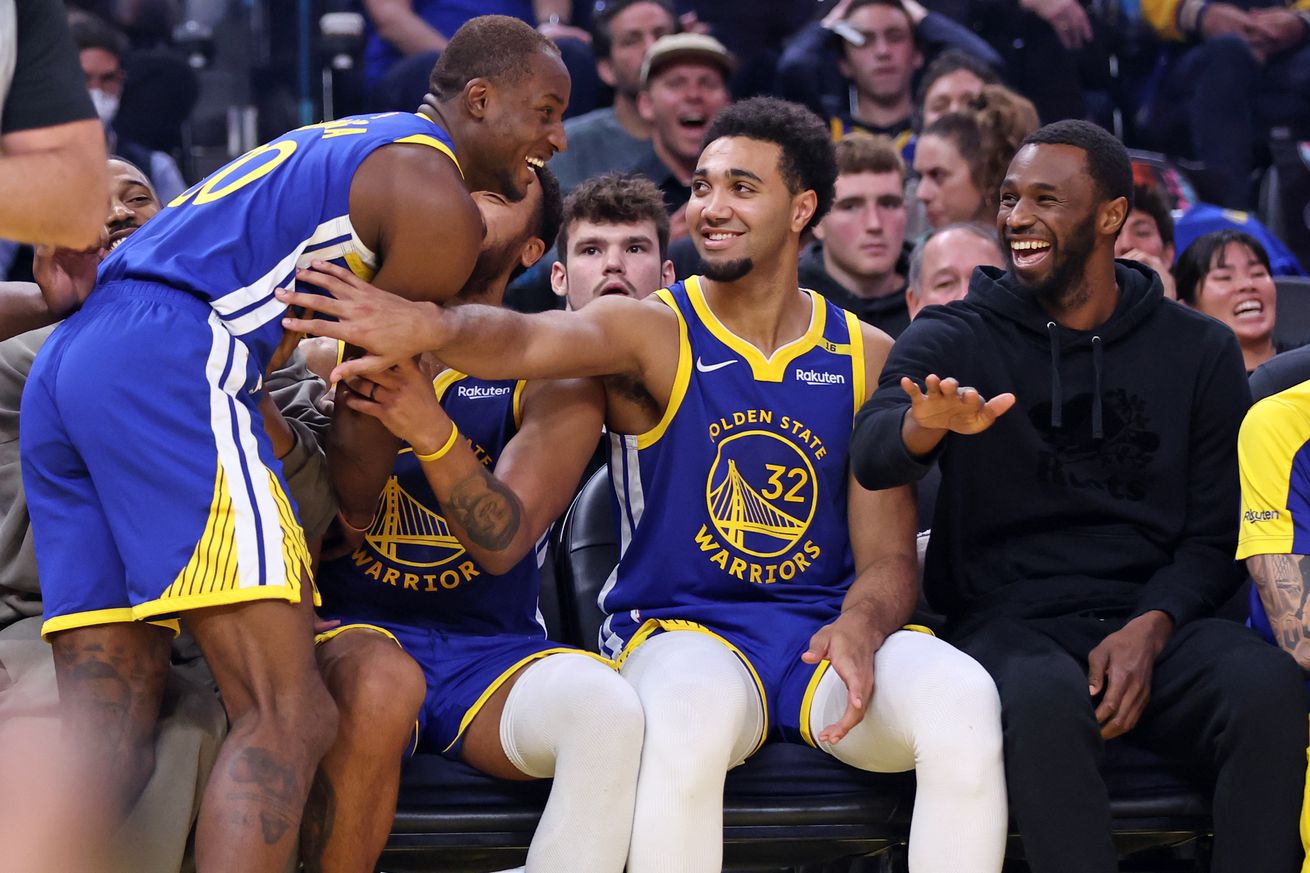 Trayce Jackson-Davis on the bench high-fiving Jonathan Kuminga.
