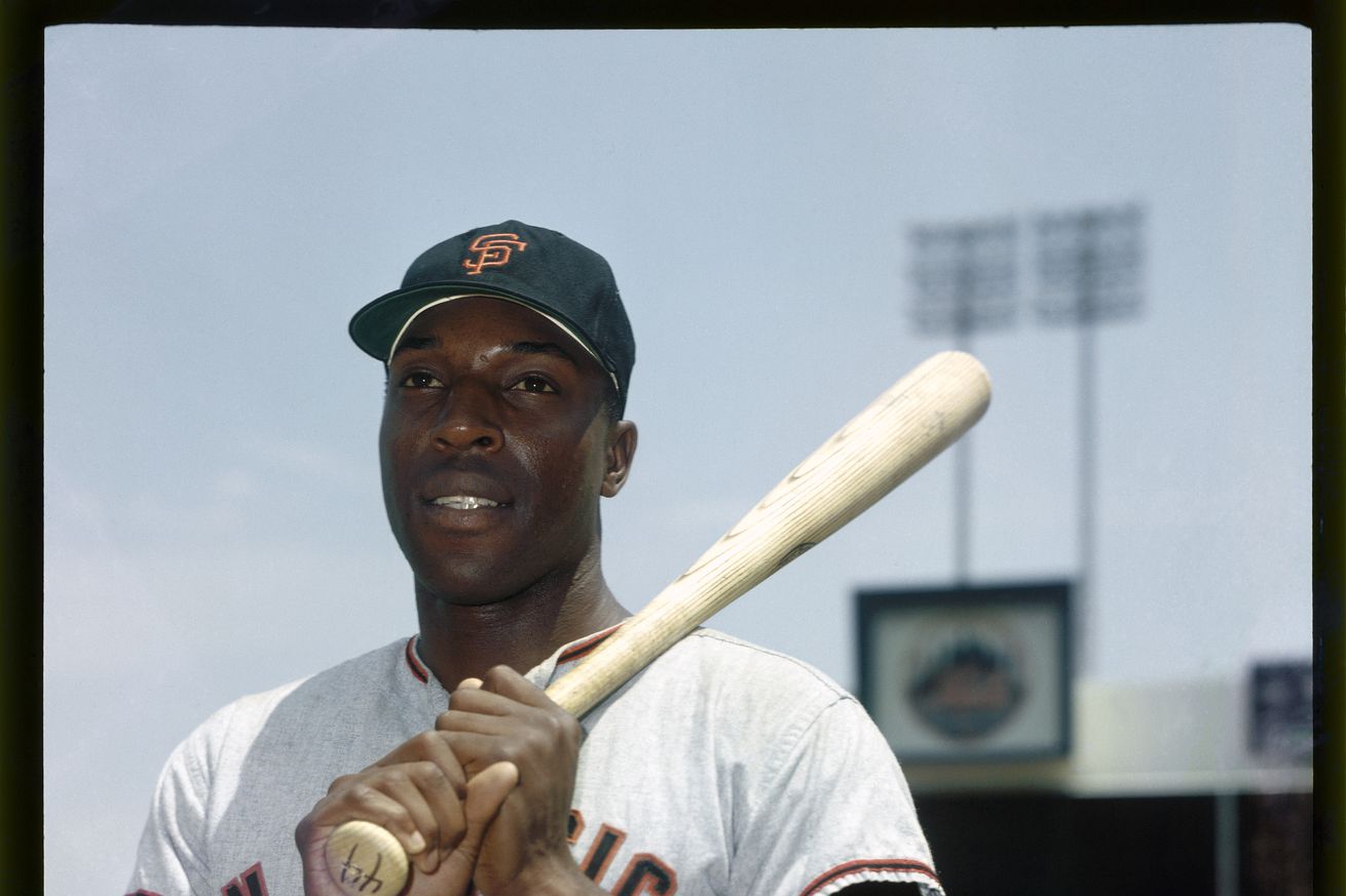 Willie McCovey posing with a bat at Shea Stadium.