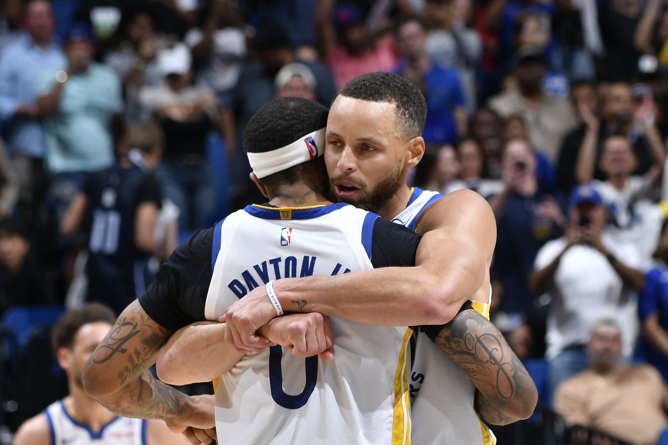 Close up of Steph Curry hugging Gary Payton II hugging at halfcourt.