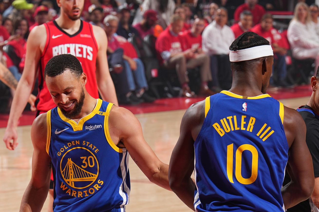 Steph Curry walking off the court, high-fiving Jimmy Butler III.