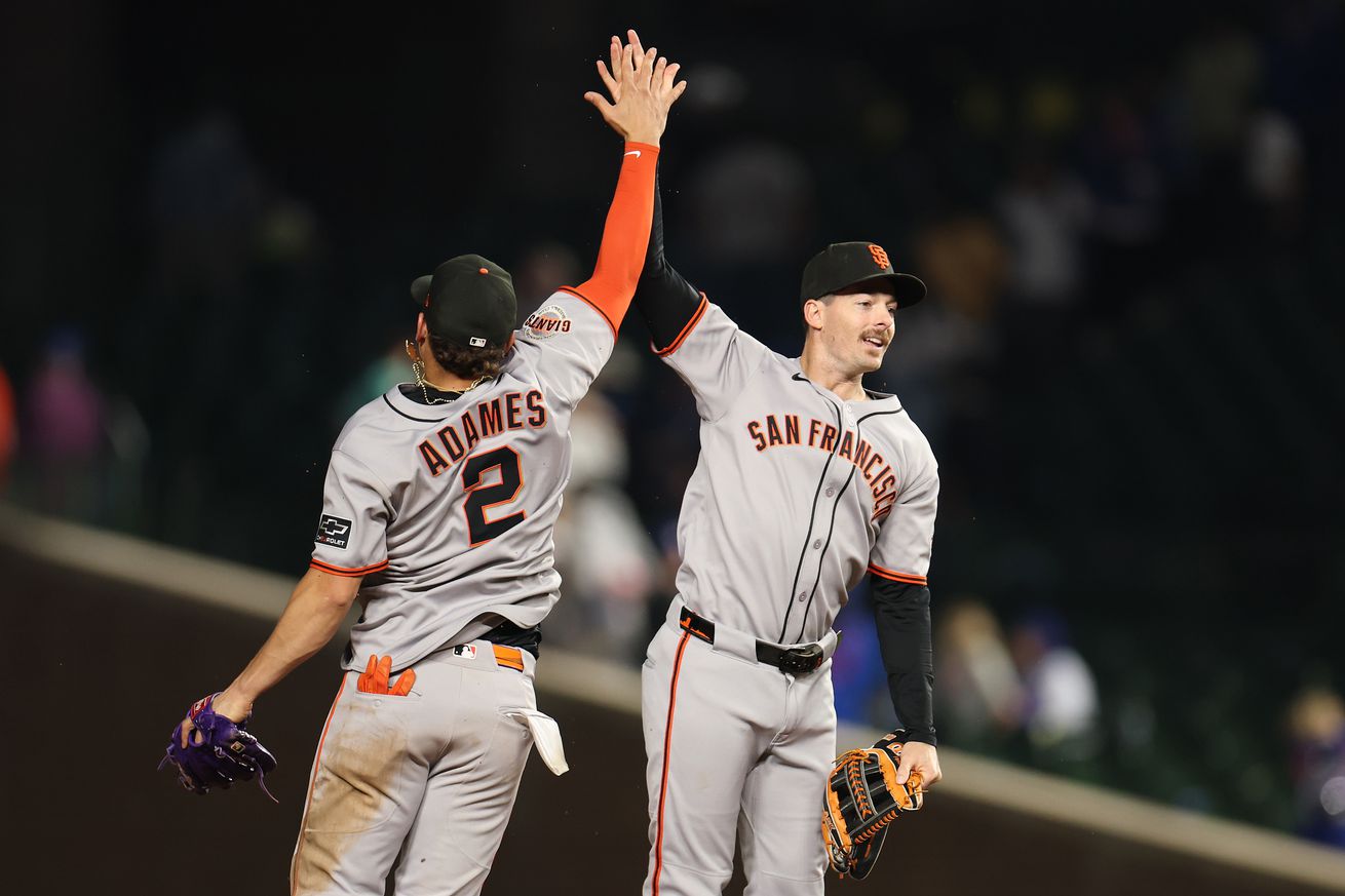Willy Adames and Mike Yastrzemski high-fiving in mid-air.