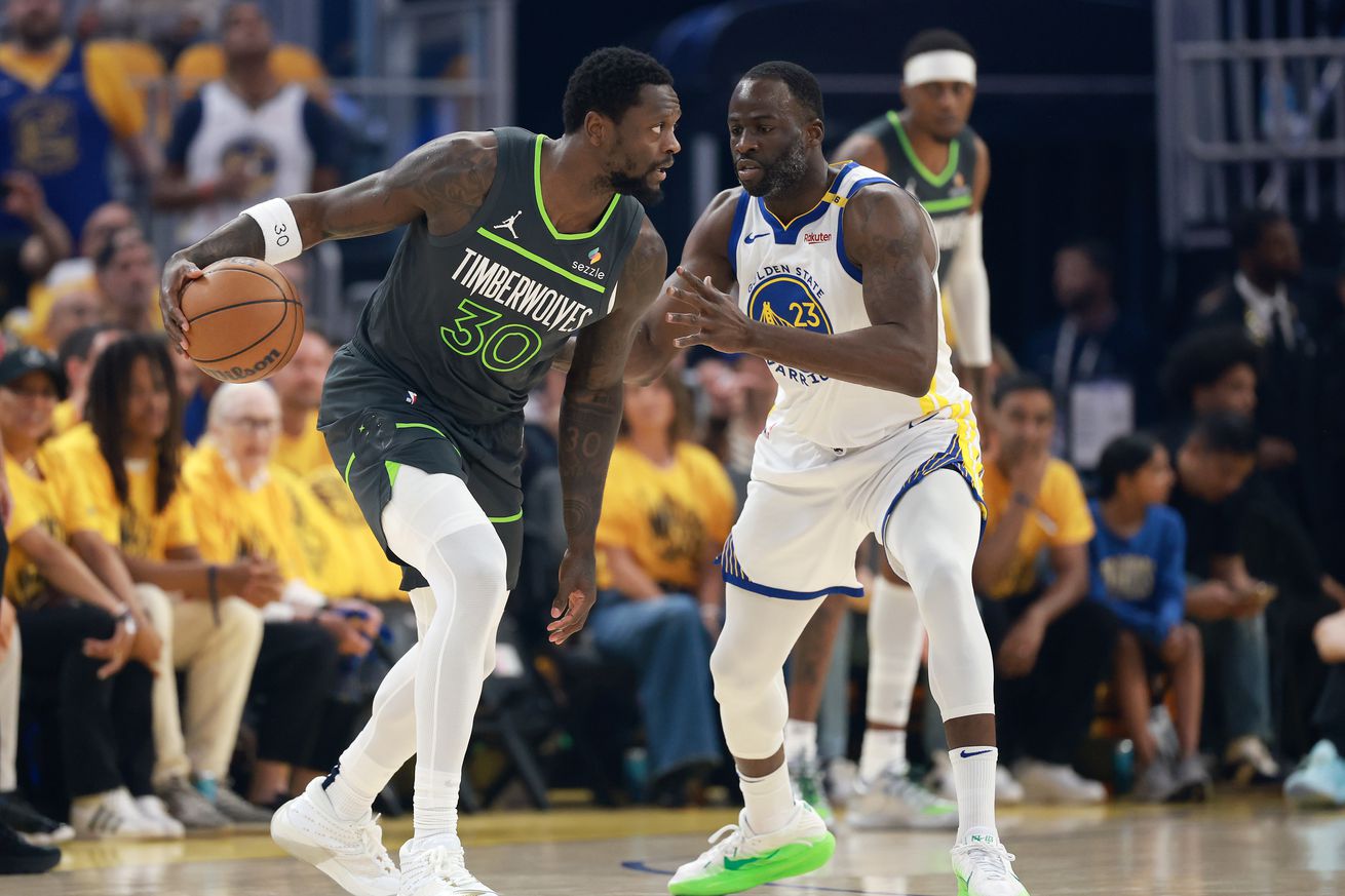 Julius Randle dribbling while defended by Draymond Green.