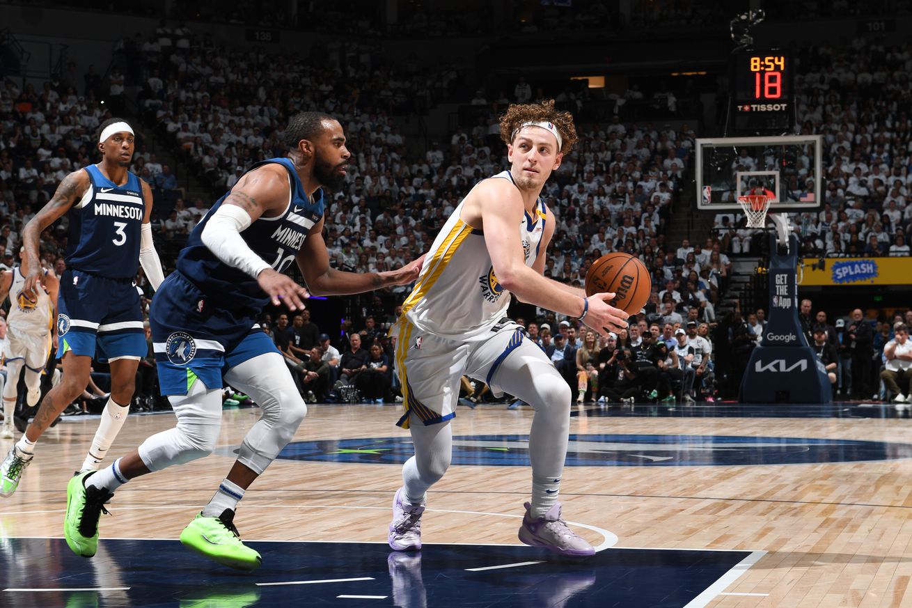 Brandin Podziemski dribbling with his left hand while defended by Mike Conley.