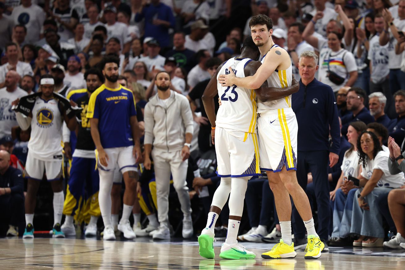 Draymond Green and Quinten Post hugging in front of the Warriors bench and a lot of Timberwolves fans.