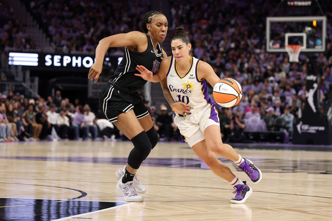 Kelsey Plum dribbling with her left hand while defended by Kayla Thornton.