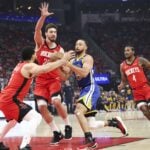 Houston Rockets guard Fred VanVleet (5) and center Alperen Sengun (28) defend against Golden State Warriors guard Stephen Curry (30) during the first quarter during game two of the first round for the 2024 NBA Playoffs at Toyota Center.