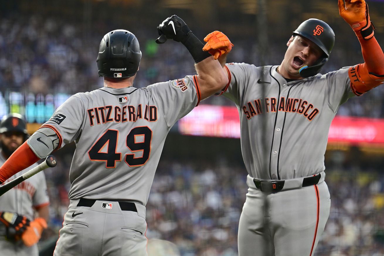 Casey Schmitt and Tyler Fitzgerald smacking arms after a home run. 