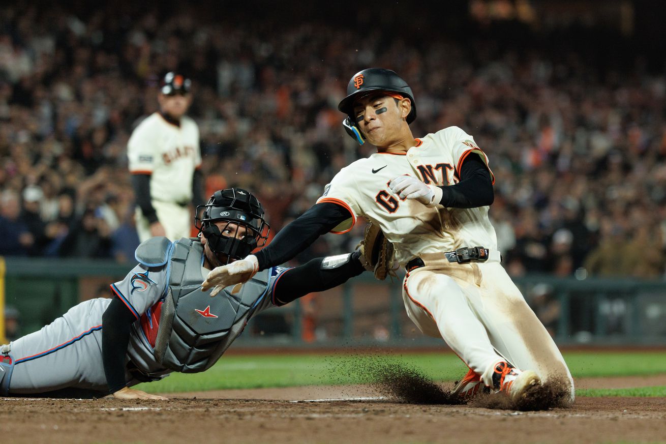 Jung Hoo Lee trying to evade a tag at home plate.