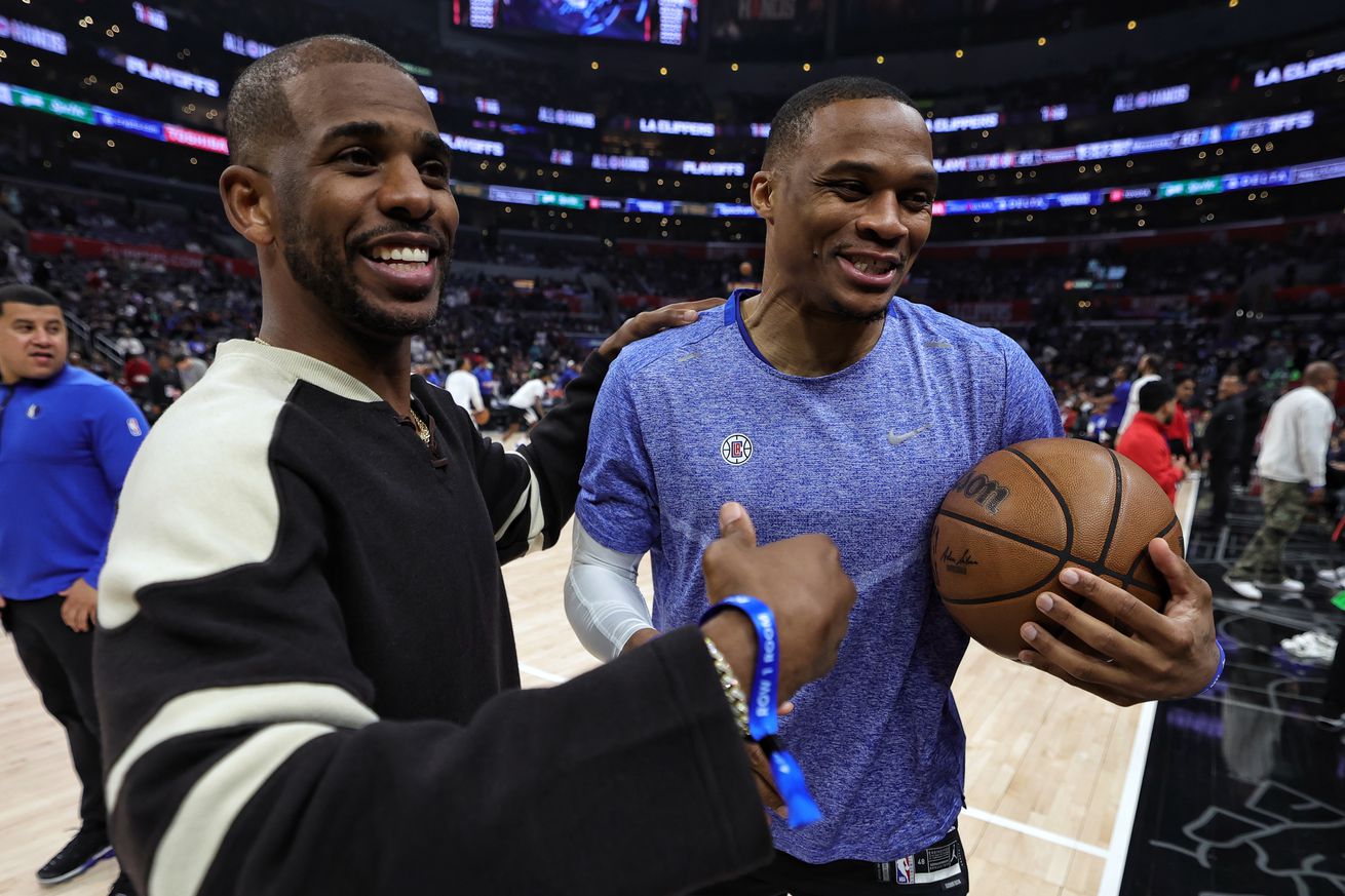 Chris Paul and Russell Westbrook smiling and embracing after a game.
