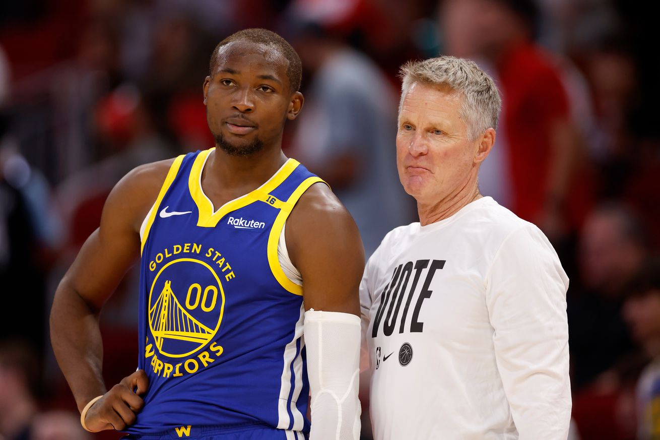 Jonathan Kuminga standing next to Steve Kerr. 