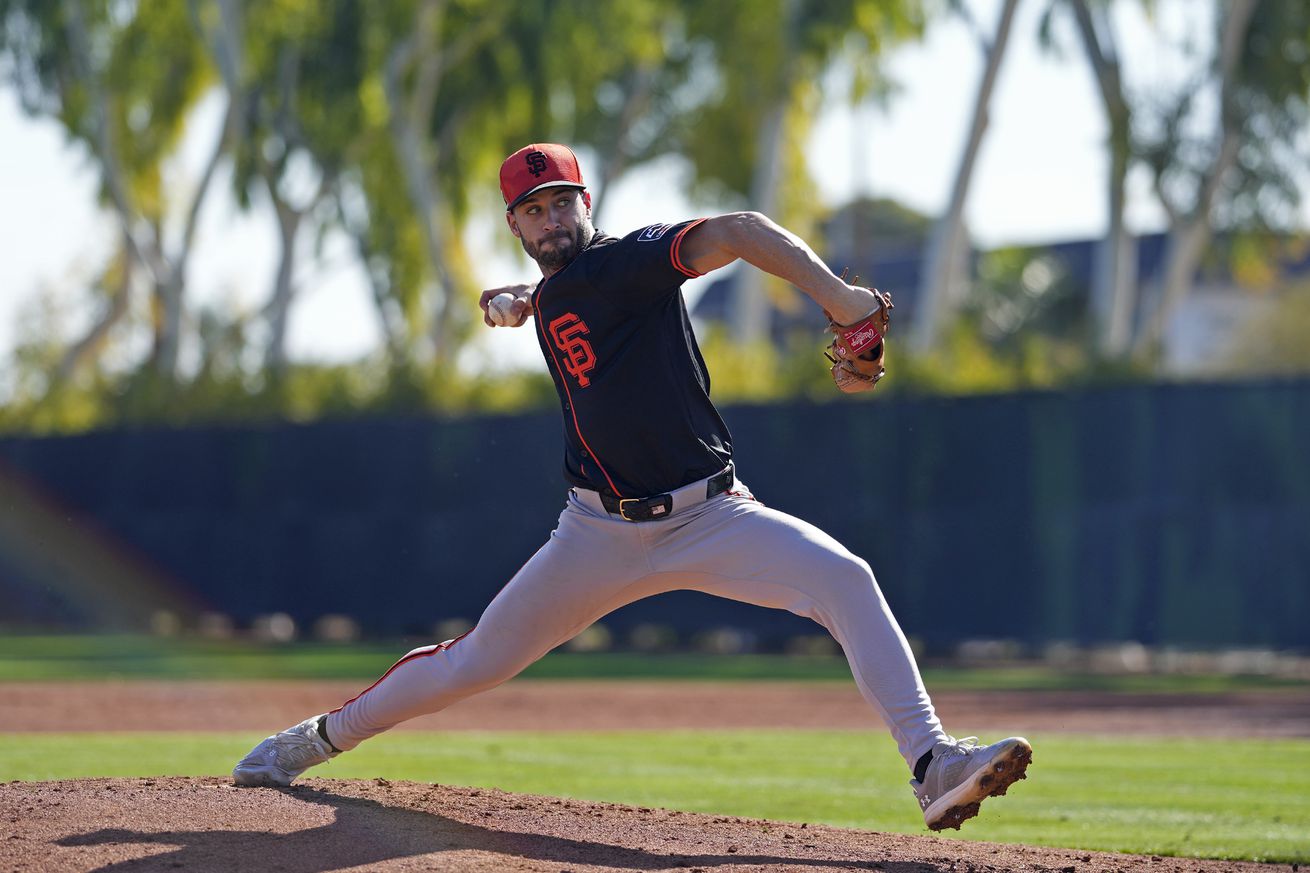 Trevor McDonald reaching back to throw a pitch during Spring Training batting practice.