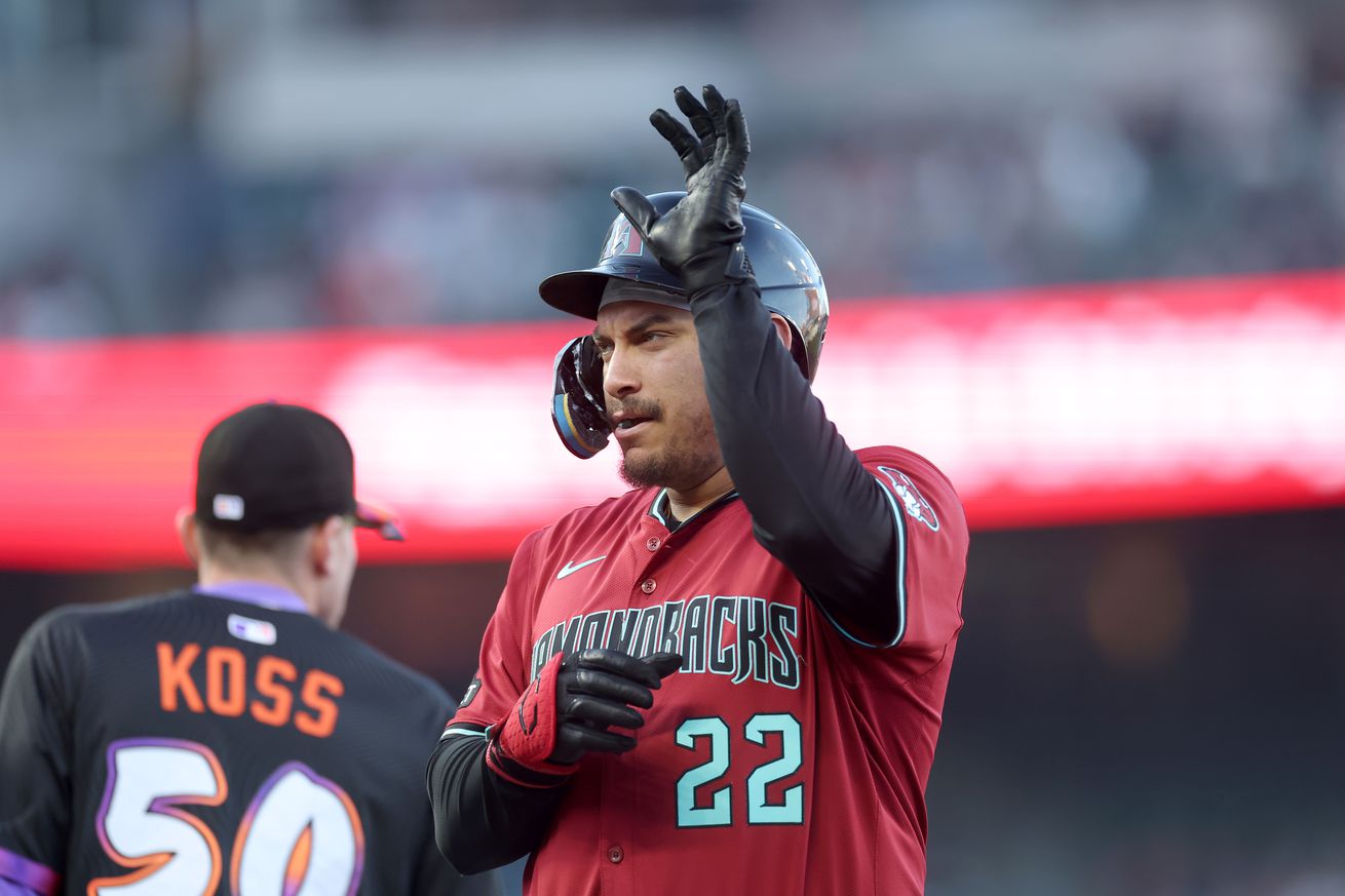 Josh Naylor motioning from first base while Christian Koss walks behind him.