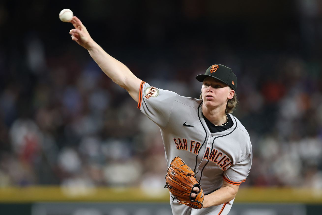 View from the front of Hayden Birdsong with his arm extended, throwing a pitch.