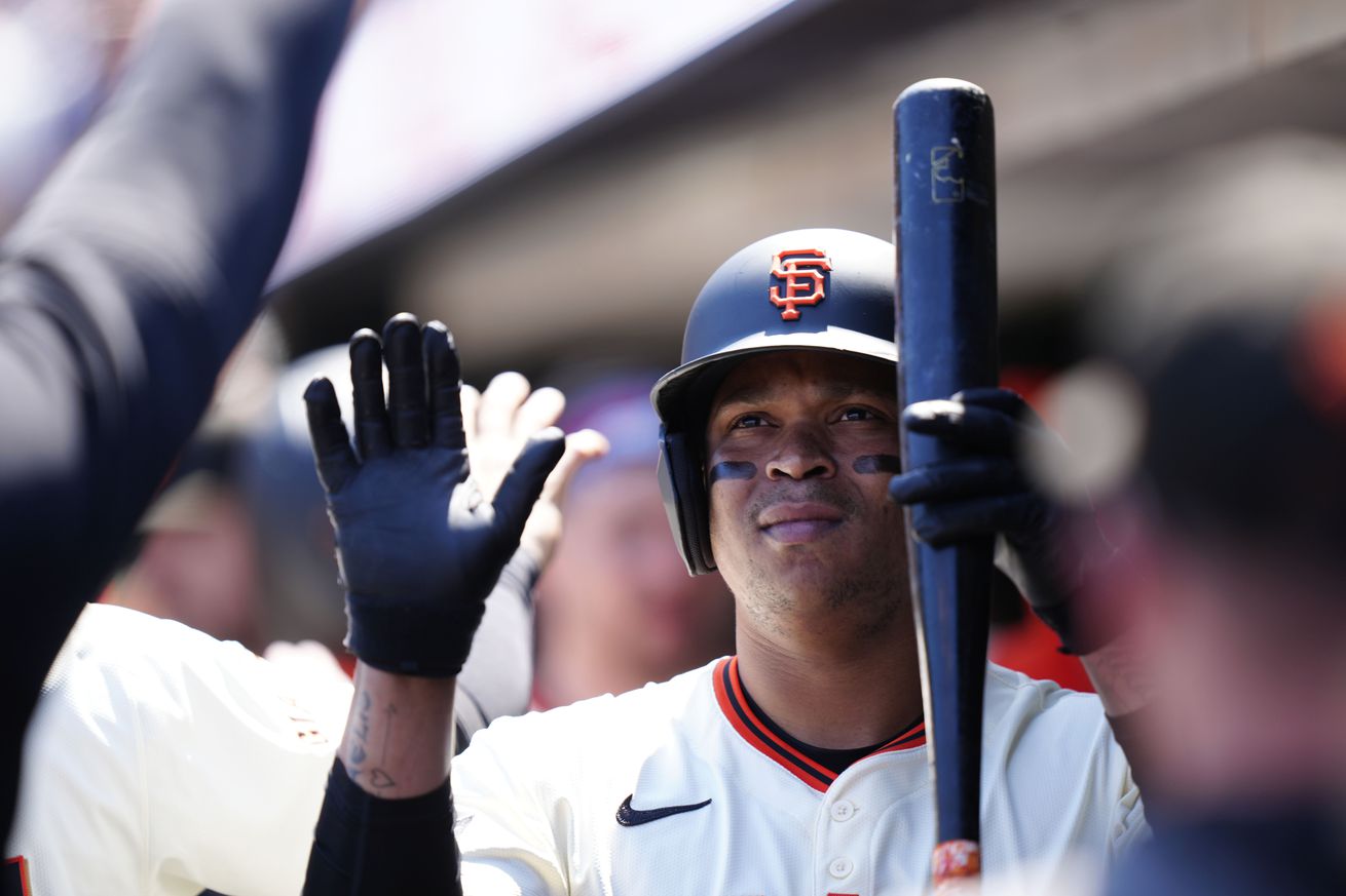 Rafael Devers holding a bat in the dugout.