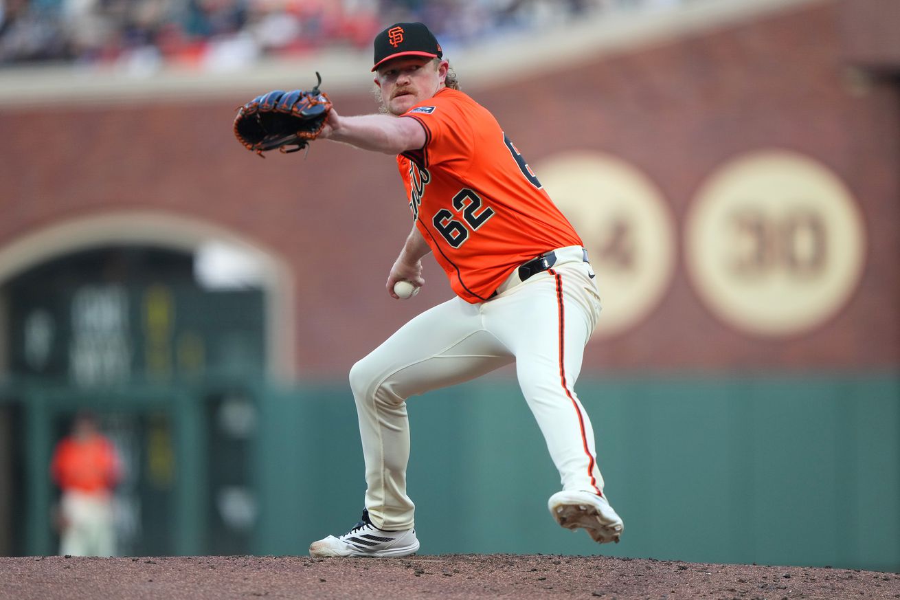 Logan Webb, in an orange jersey, reaching back to throw a pitch. 