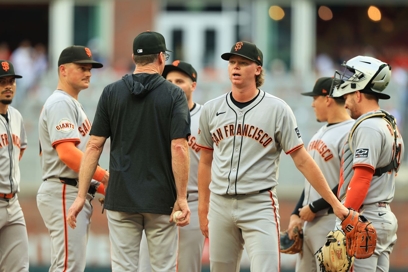 Hayden Birdsong walking off the mound while Bob Melvin and the infielders stand together.