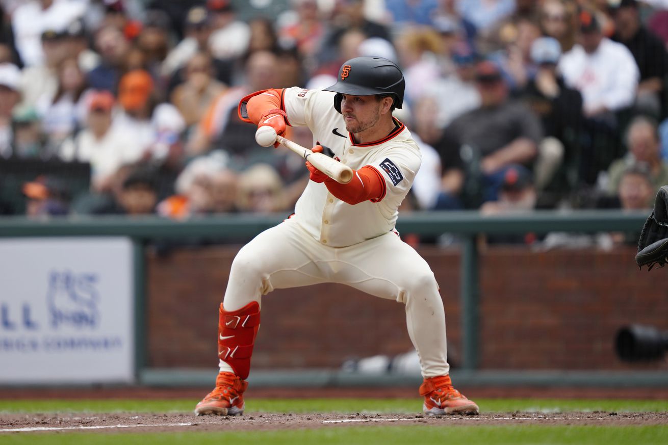 Patrick Bailey squatting to lay down a bunt.