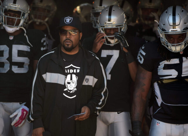 Oct 19, 2014; Oakland, CA, USA; Recording artist and entertainer Ice Cube leads Oakland Raiders players onto the field before the game against the Arizona Cardinals at O.co Coliseum. Mandatory Credit: Kirby Lee-USA TODAY Sports Ice Cube, Raiders