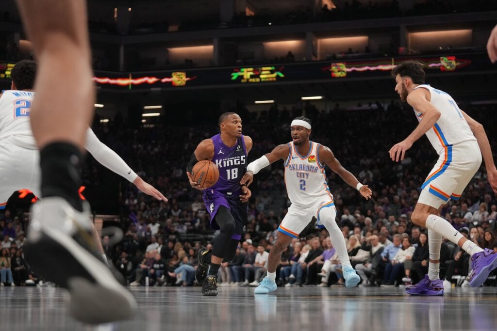 Sacramento Kings guard Russell Westbrook (18) dribbles the ball next to Oklahoma City Thunder guard Shai Gilgeous-Alexander (2) in the first quarter at the Golden 1 Center.