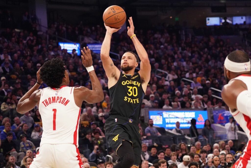 Nov 26, 2025; San Francisco, California, USA; Golden State Warriors guard Stephen Curry (30) shoots while defended by Houston Rockets guard-forward Amen Thompson (1) in the second quarter at Chase Center. Mandatory Credit: David Gonzales-Imagn Images