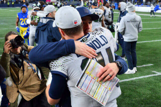 Dec 18, 2025; Seattle, Washington, USA; Seattle Seahawks quarterback Sam Darnold (14) hugs offensive coordinator Klint Kubiak after defeating the Los Angeles Rams in overtime at Lumen Field. Mandatory Credit: Steven Bisig-Imagn Images Klint Kubiak, Seahawks, Raiders, Sam Darnold